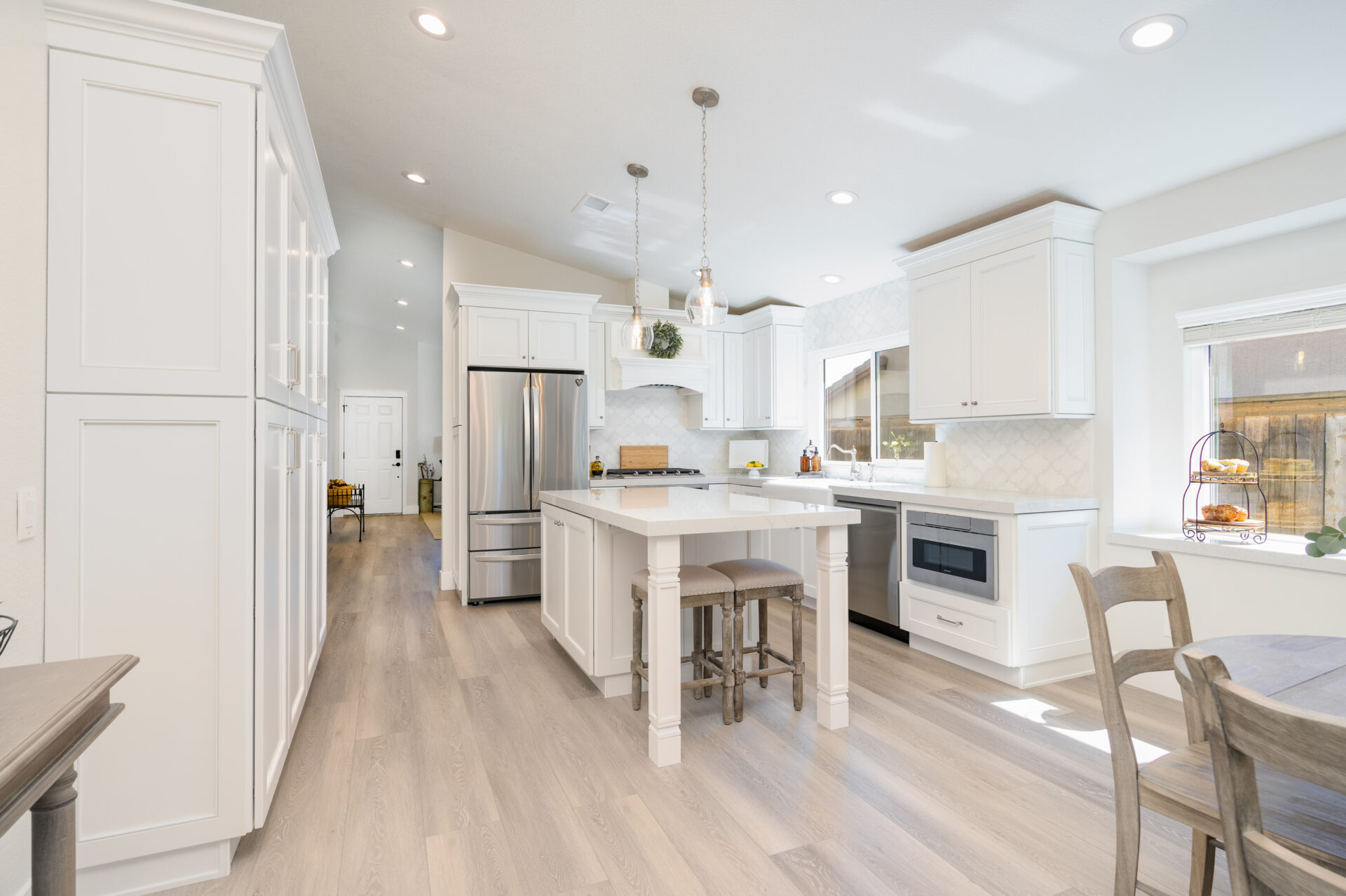 Bright remodeled kitchen with dark island and white cabinetry